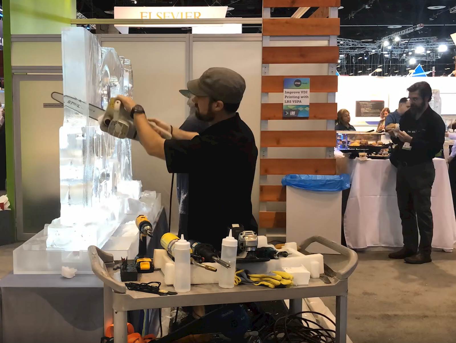 artist making ice sculpture with chain saw